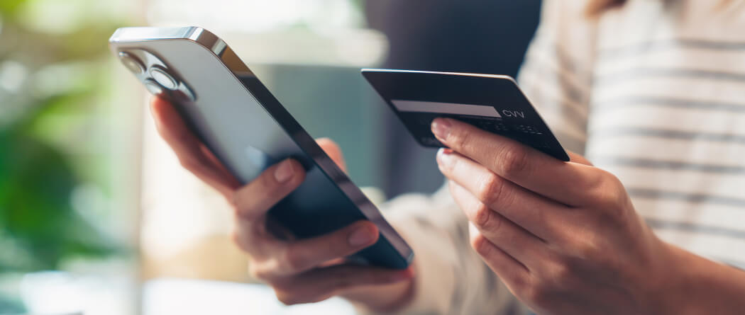 Close-up of hands holding a smartphone and credit card