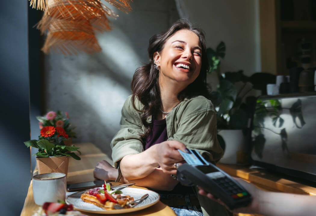 Young woman paying for food with a credit card